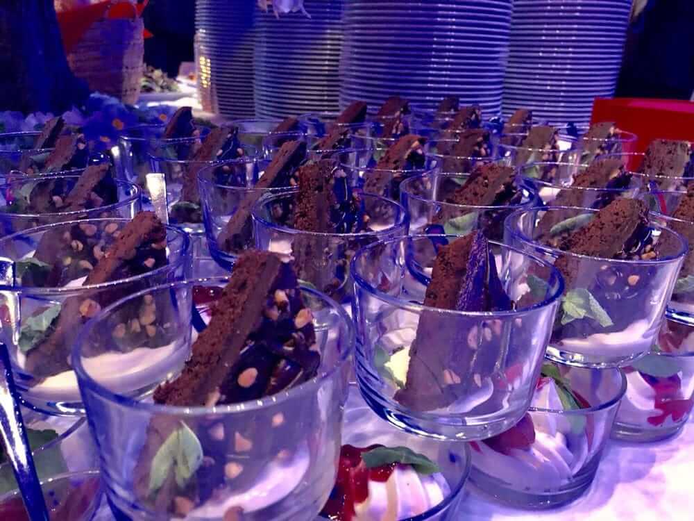 Mehrere Gläser mit Dessert, darin Schokokuchenstücke, Nüsse und frische Minze