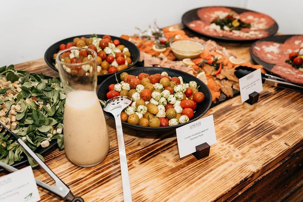 Ein rustikales Buffet mit buntem Tomatensalat, Dressing und frischen Vorspeisen